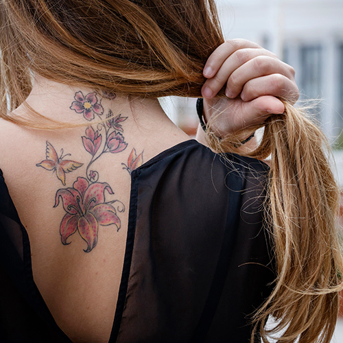 tatouage femme fleur colorée dans le dos